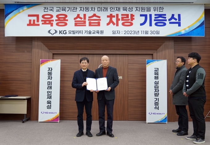 KG 모빌리티(이하 KGM) 오석진 기술교육원장이(사진 왼쪽) 교육기관 대표인 순천제일대학교 정동화 교수가(사진 오른쪽) 에게 기증서를 전달하고 기념사진을 촬영하고 있다.