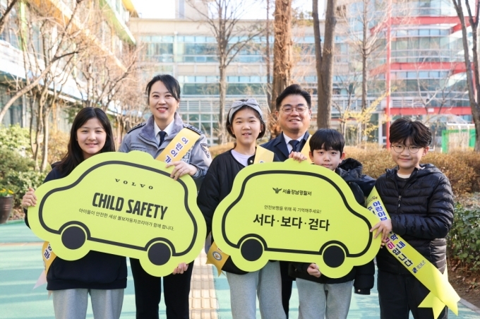 (왼쪽부터) 서울강남경찰서 교통과장 송지영 경정, 볼보자동차코리아 이만식 전무, 언북초등학교 학생들이 기념사진 촬영을 하고 있다.