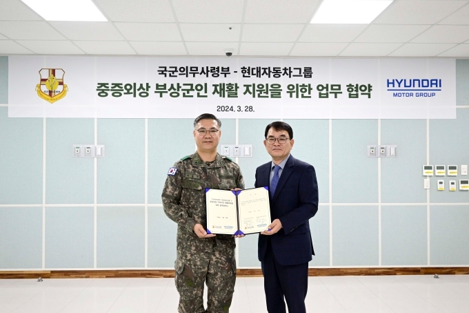 (왼쪽부터) 국군의무사령관 하범만 준장, 기아 특수사업부장 김익태 전무가 기념 촬영을 하고 있다.
