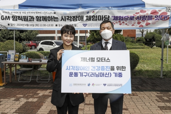 지엠한마음재단 윤명옥 사무총장(왼쪽)이 인천광역시시각장애인복지관 이춘노 관장과 함께 시각장애인 전용 러닝머신 기증식 기념 사진촬영을 하고 있다.
