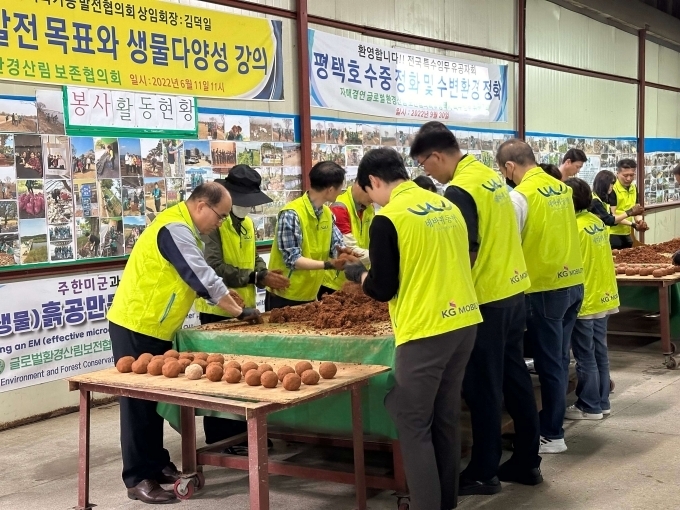 KGM 사내 봉사단 네바퀴동행을 비롯한 참가자들이 하천을 정화하기 위해 EM흙공을 제작하고 있다.