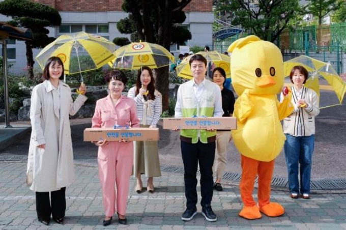 29일 인천 동수 초등학교에서 진행된 ‘안전하게 건너요’ 캠페인에서 GM 커뮤니케이션 총괄 및 CMO 윤명옥 전무(앞줄 왼편), 굿네이버스 이필승 인천지역본부장(앞줄 오른편)을 비롯해 GM 임직원 들이 안전 키트를 들고 있는 모습.