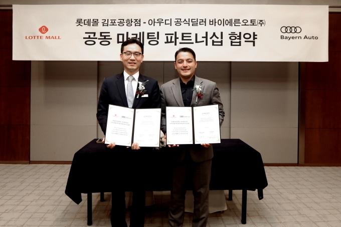 롯데몰 김포공항 협의체 김동수 점장(왼쪽)과 바이에른오토(주) 권혁민 대표(오른쪽)이 기념 사진을 촬영하고 있다,