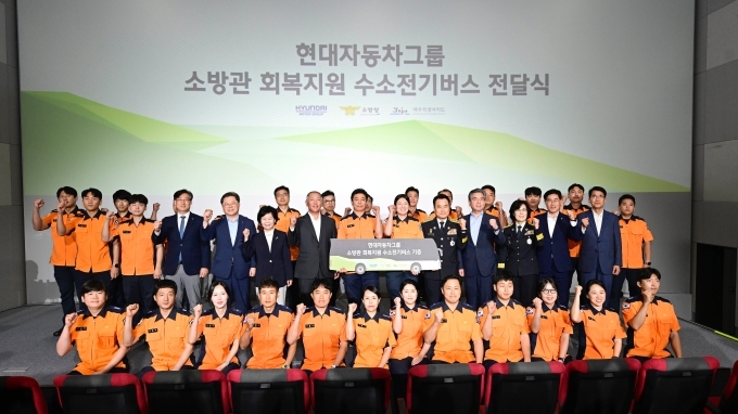 가운데줄 왼쪽부터/정의선 현대차그룹 회장(여섯 번째), 장재훈 현대차 사장(열 번째), 남화영 소방청장(아홉 번째), 김애숙 제주도 정무부지사(다섯 번째), 고민자 제주소방안전본부장(열한 번째), 박일준 대한상의 상근부회장(네 번째) 등 행사 참석자들과 소방관들이 단체 기념 사진을 찍고 있다.