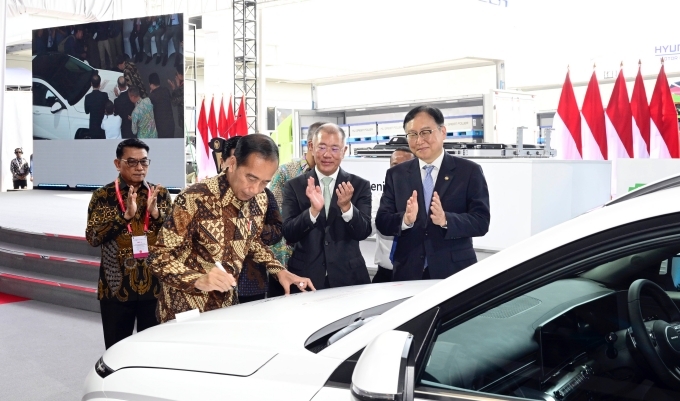 조코 위도도(Joko Widodo) 인도네시아 대통령이 HLI그린파워에서 생산한 배터리셀을 탑재한 디 올 뉴 코나 일렉트릭 1호차에 서명하고 있는 모습. 사진 오른쪽부터 정인교 통상교섭본부장, 정의선 현대차그룹 회장, 조코 위도도 인도네시아 대통령