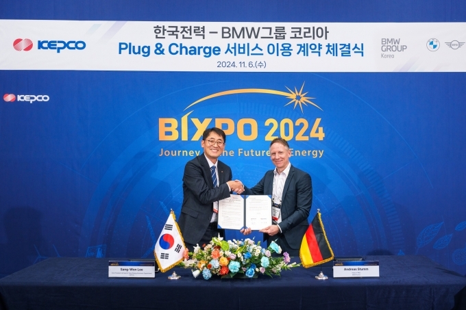 안드레아스 스툼 BMW 그룹 R&D 센터 코리아 총괄(오른쪽)과 이상원 한국전력 에너지신사업처장(왼쪽)이 PnC 충전 서비스 이용 계약 체결식에서 기념촬영을 하고 있다.