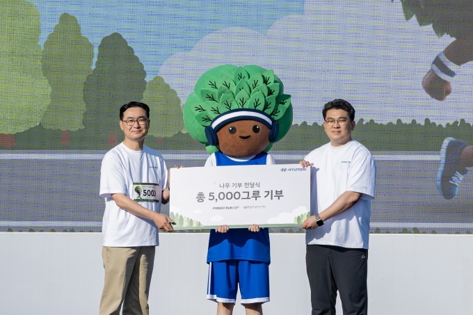 현대차 국내사업본부 정유석 부사장, 함께일하는재단 이원태 사무국장, ‘포레스트런’의 새로운 마스코트 ‘그루’가 식재 기부 전달식 기념 촬영을 하고 있다.