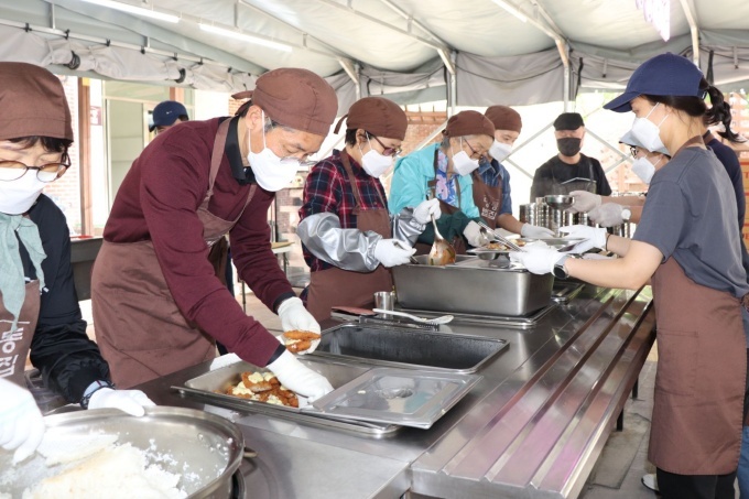 봉사활동에 참여한 정인국 케이카 사장(좌측 두번째)이 봉사자들과 함께 식사 준비를 돕고 있다.