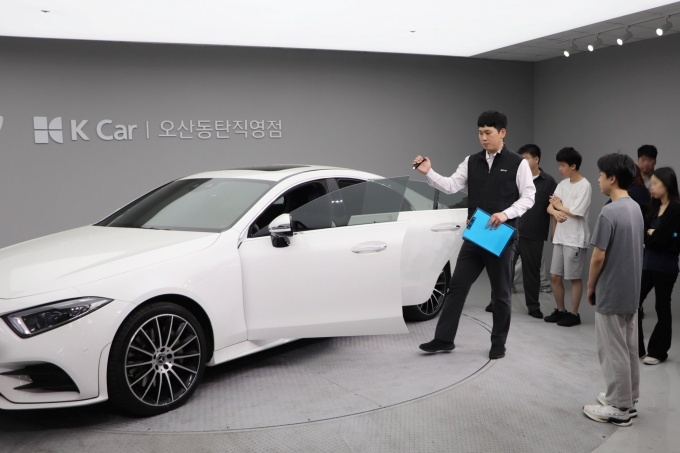 성강훈 케이카 오산동탄지점 판매실장이 학생들에게 차량 진단 과정을 설명하고 있다.