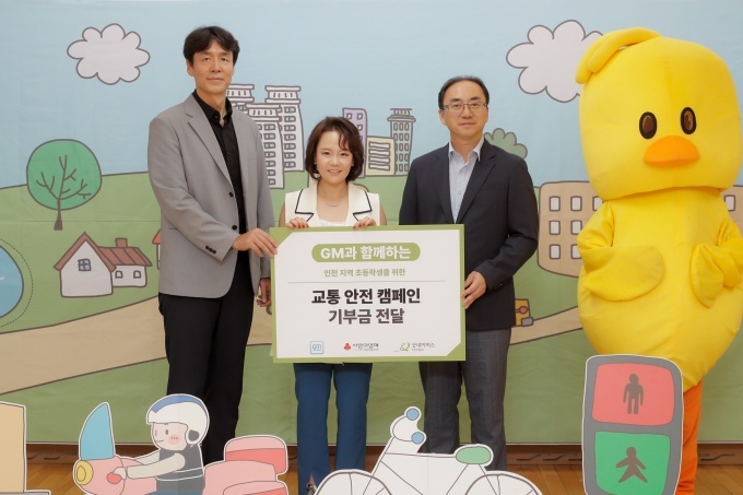 GM과 함께하는 인천 지역 초등학생을 위한 교통 안전 캠페인 기부금 전달식에서 기념 사진을 촬영하고 있는 윤명옥 GM 한국사업장 최고마케팅책임자(CMO) 겸 커뮤니케이션 총괄 전무(가운데), 홍상진 굿네이버스 인천사업본부 본부장(왼쪽), 이지훈 명선초등학교 교장(오른쪽)