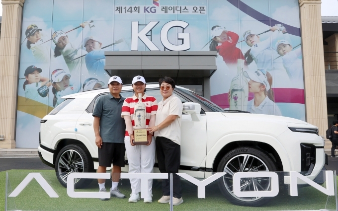 제14회 KG 레이디스 오픈’ 우승자 신다은 선수가 부상으로 받은 액티언 하이브리드 차량 앞에서 부모님과 기념 촬영을 하고 있다.
