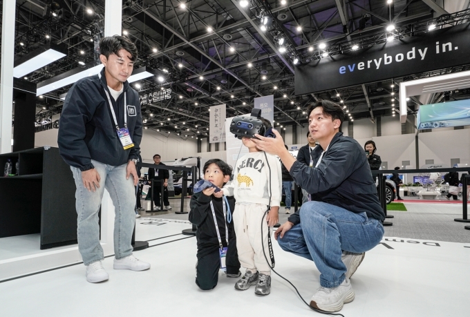 2025 대한민국 미래모빌리티엑스포(DIFA) GM 부스의 이머시브 존에서 차량 개발 기술을 체험하고 있는 관람객들의 모습