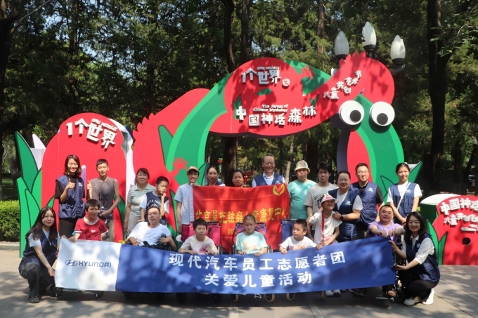 2025년 6월 중국 어린이날을 맞아 중국 북경에 위치한 중국아동센터에서 현대차 임직원들과 뇌성마비 어린이들이 예술전을 관람한 후 기념사진을 촬영하는 모습.