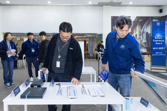 2025 GM 테크 데이의 배터리 체험존에서 배터리 셀을 관람하고 있는 관람객들