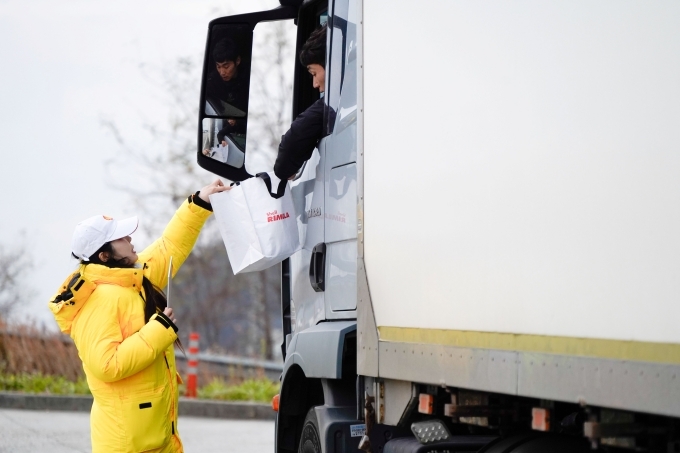 ‘리무라 졸음운전 방지 캠페인’행사 관계자가 대형 트럭 운전자에게 안전 패키지를 전달하고 있다.