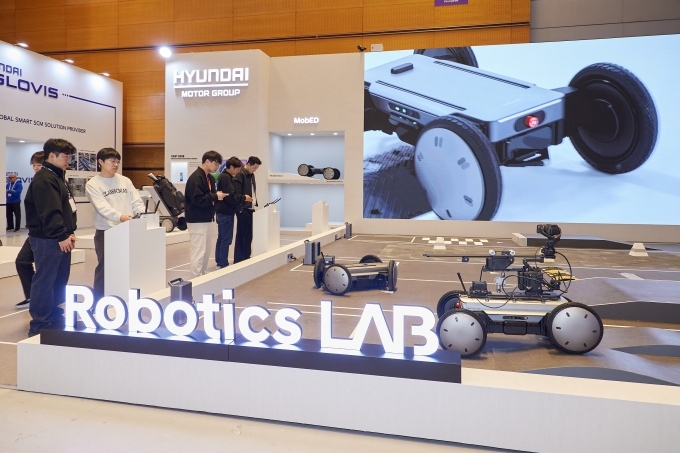 AW2026 전시장 내 현대차·기아 로보틱스랩 부스에서 관람객들이 모베드를 직접 체험 조작하는 모습