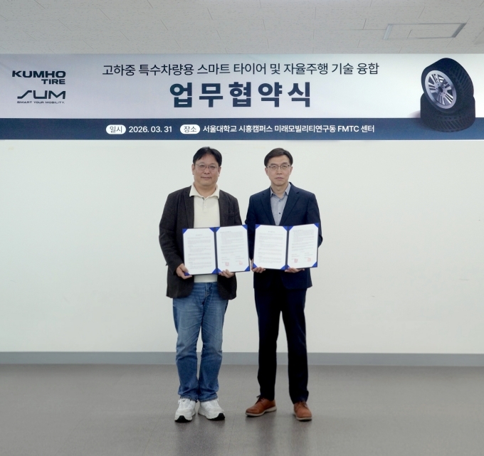 지난달 31일 에스유엠 본사에서 열린 협약식에서 금호타이어 연구개발본부장 김영진 전무(사진 오른쪽)와 에스유엠 현영진 대표이사(사진 왼쪽)가 기념 사진을 촬영하고 있다.